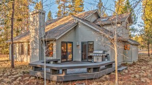A cabin with a deck, a grill, and a sliding glass door. - Towhee Lane 5 (Bend)