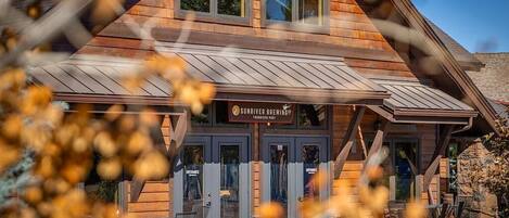 A wooden building with a sign that reads "Sunriver Brewing." There are two doors labeled "Entrance."