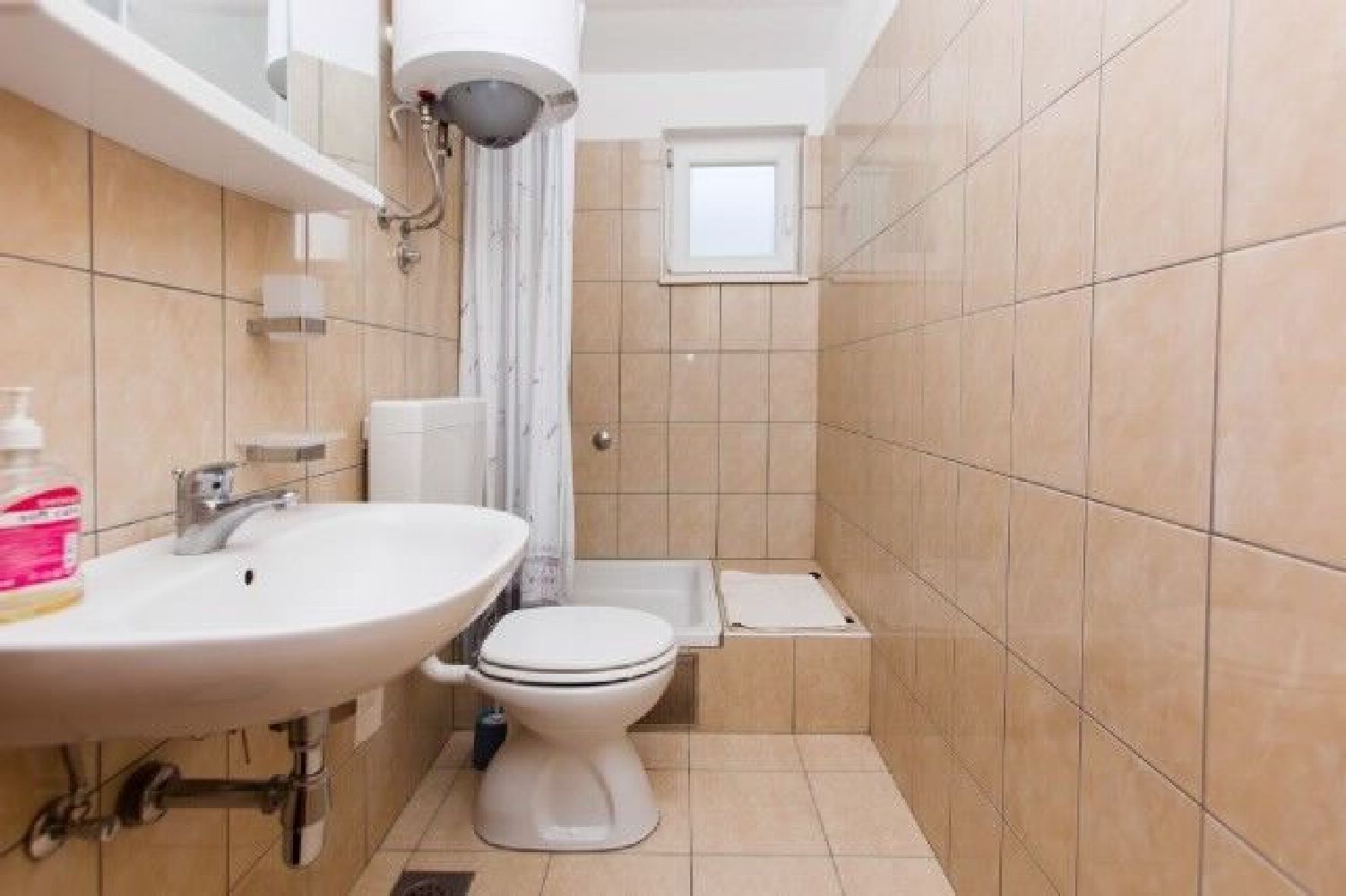 Un bagno piccolo con lavandino, WC e doccia.