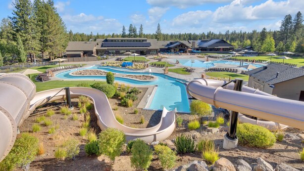 Un resort con varias piscinas, un tobogán de agua y un edificio grande con un telesilla.