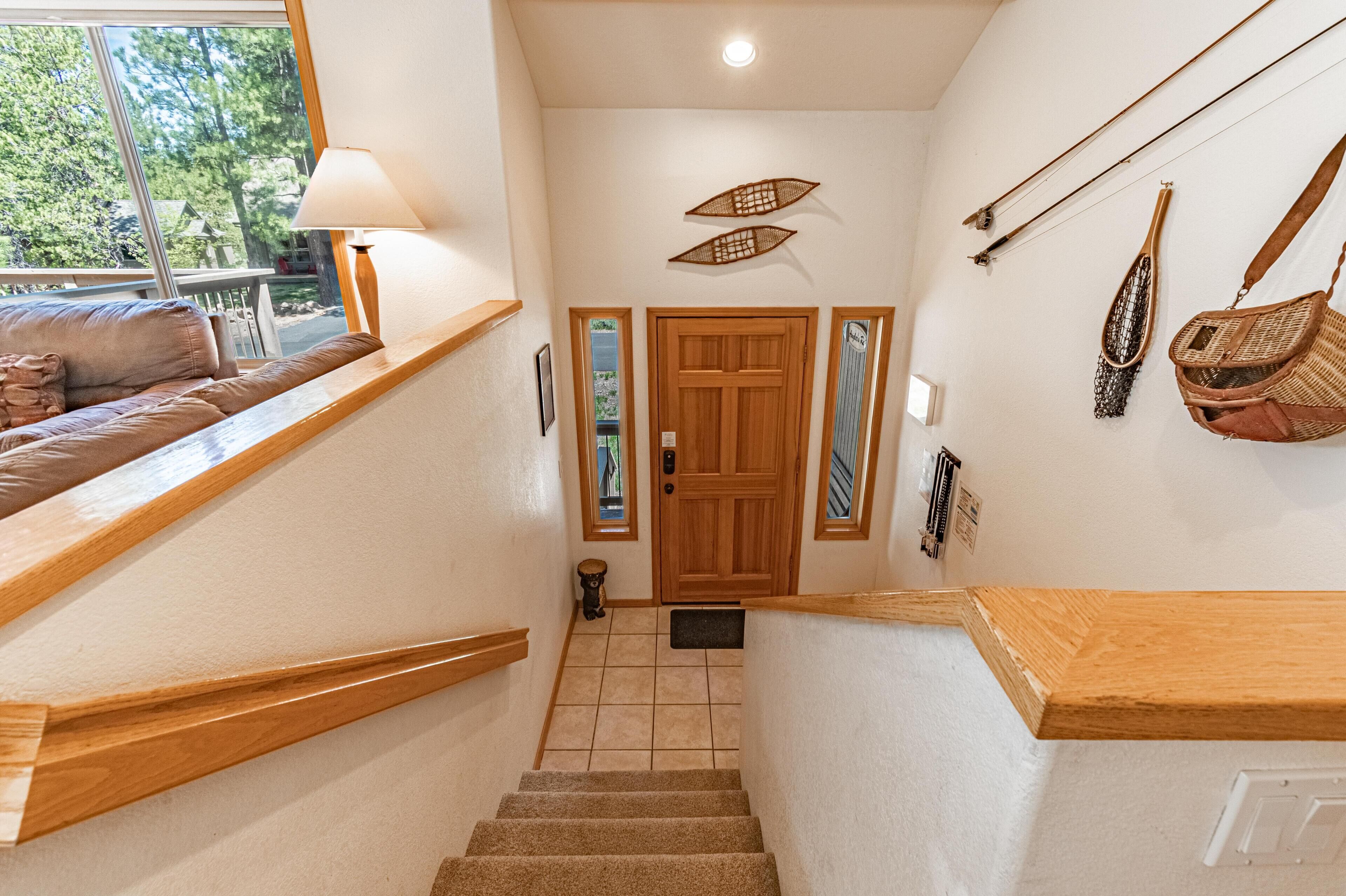 A staircase with wooden handrails, a wooden door, and a view of the outdoors through a window.