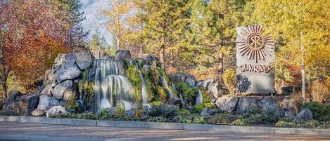A waterfall with a sign that reads "SUNRIVER."