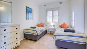 A bedroom with two beds, a dresser, a window, and a picture on the wall. - Ruby is the precious jewel in the heart of Exmouth. (Exmouth)