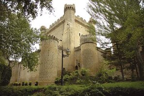 A historic stone castle with a central tower, surrounded by lush greenery and a paved pathway. - Sajazarra Holiday House Single Famil House Located in the Village of Sajasarra, (Sajazarra)