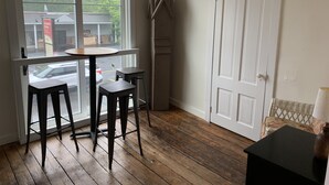 A room with a large window, a door, and two stools. - Newly renovated in-town Bar Harbor, five bdrm apartment. Walk to shore & shops. (Bar Harbor)