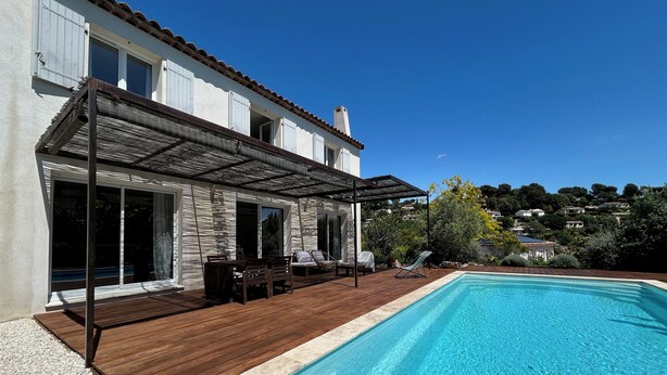 A swimming pool with a wooden deck and a covered patio area. - New house with swimming pool and large outdoor terrace. (VENCE)