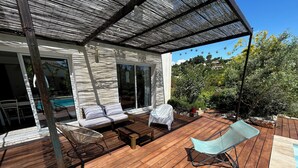 A wooden deck with a covered seating area, a pool, and a view of the surrounding landscape. - New house with swimming pool and large outdoor terrace. (VENCE)