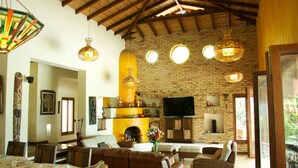 A spacious living area with a brick fireplace, comfortable seating, and a television. - Casa Mar Verde (Montenegro)