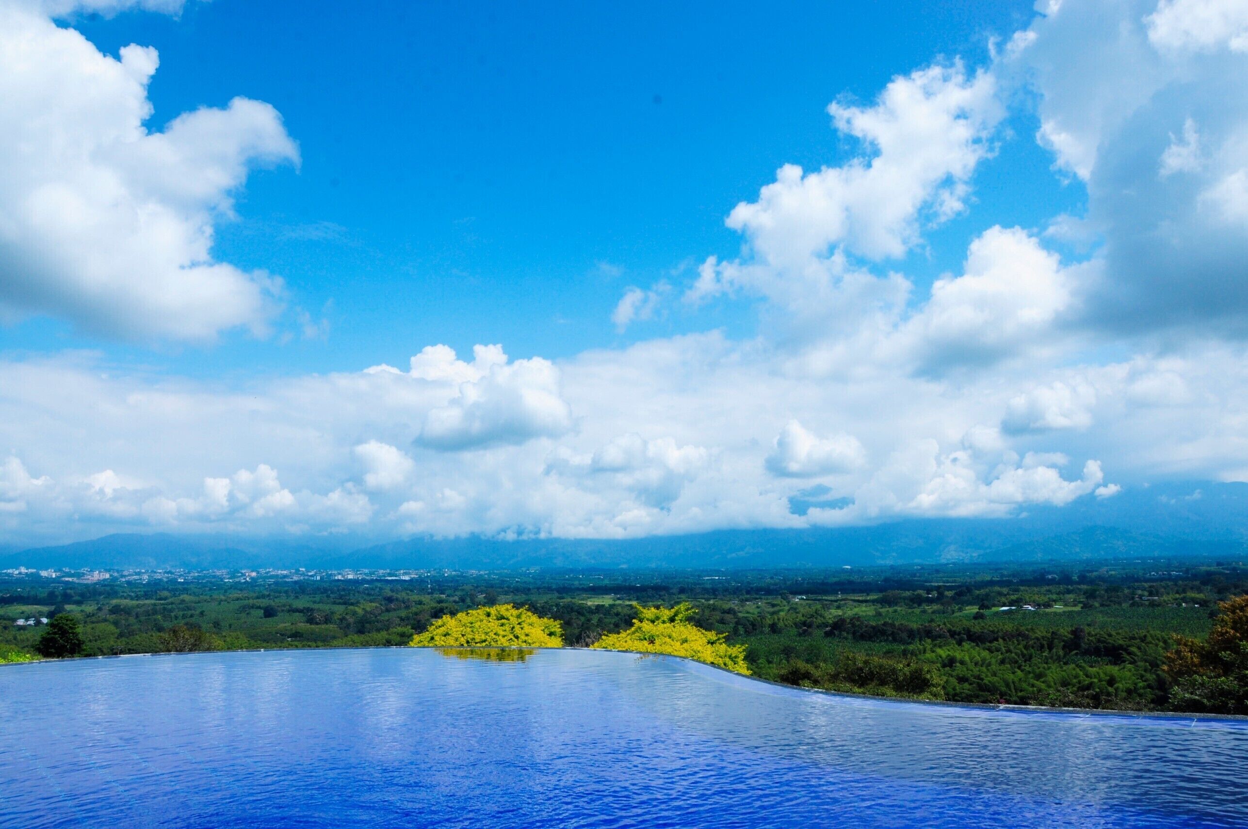 Una piscina con vistas despejadas a un paisaje y montañas lejanas.