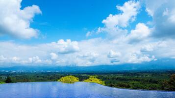 Una piscina con vistas despejadas a un paisaje y montañas lejanas.