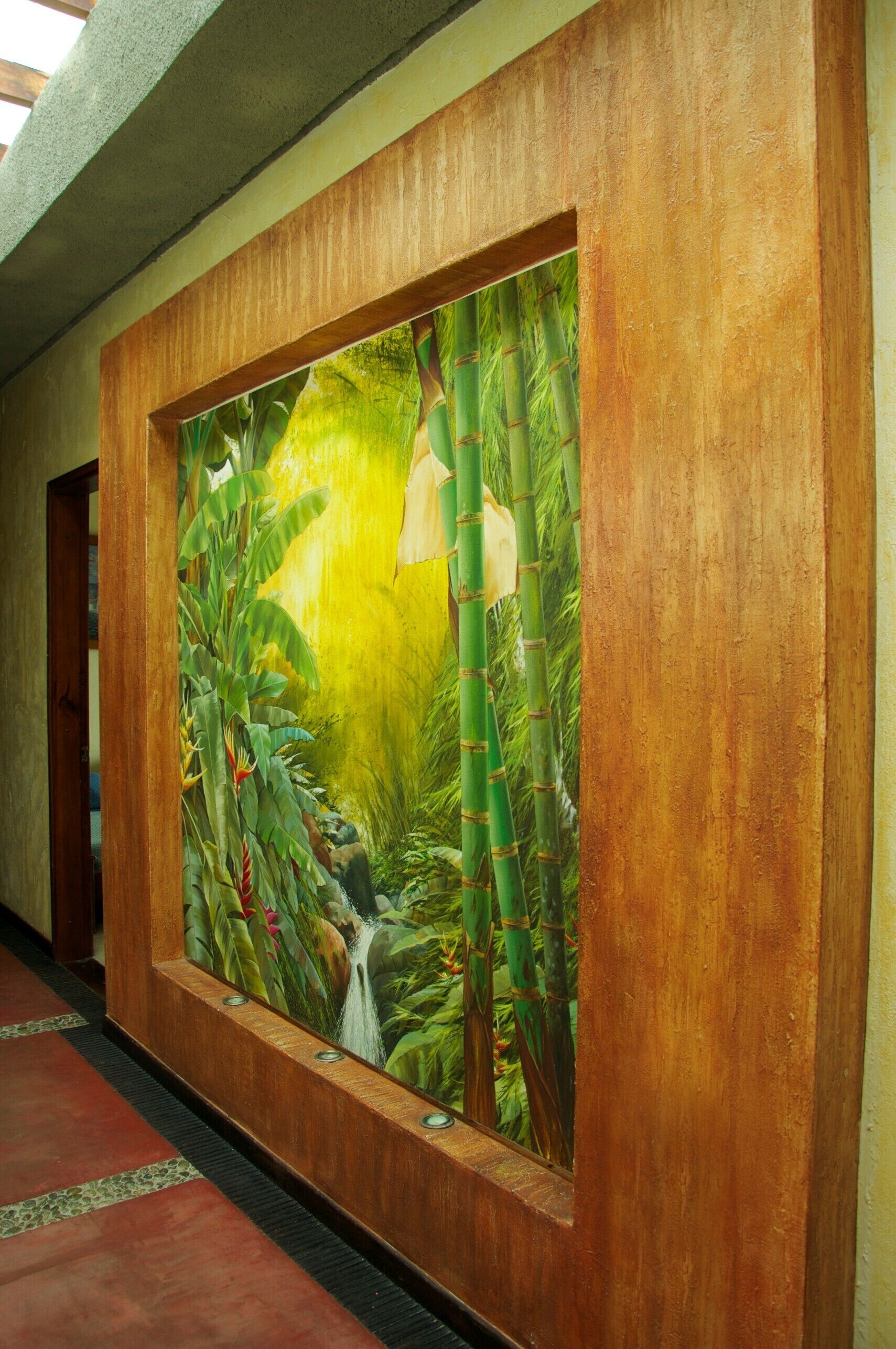 A hallway with a large mural of a jungle scene, a wooden frame, and a tiled floor.