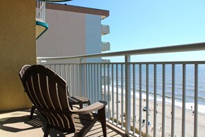 A balcony with a view of the beach and ocean.