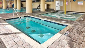 An indoor swimming pool with multiple lanes, a lifeguard station, and a poolside area with a brick floor. - Grand Atlantic by Palmetto Vacations (Myrtle Beach)