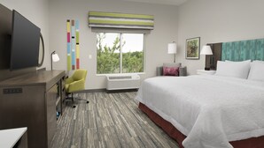 A hotel room with a bed, desk, chair, air conditioning unit, and a window with a view of trees. - Hampton Inn & Suites Lexington Columbia (Lexington)