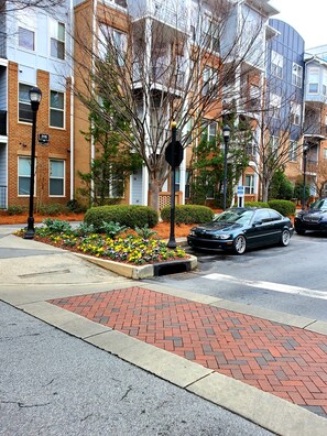 Stroll through a charming urban neighborhood lined with apartment buildings and lush greenery.