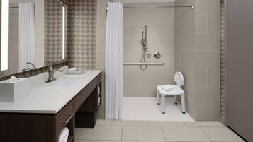Un bagno moderno con doccia, un mobile lavabo con specchio e il water.
