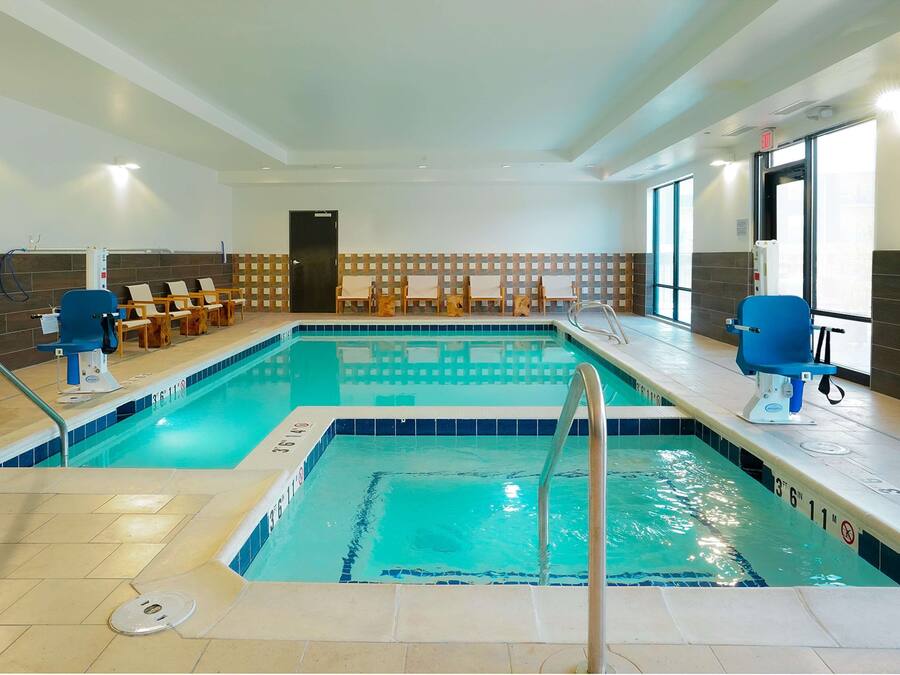 Une piscine intérieure à l’eau claire, dotée de deux postes de surveillance pour les maîtres-nageurs et d’une plage carrelée.