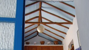 Una escalera con techo de madera y una pequeña zona de estar en la parte superior.