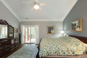 Ein Schlafzimmer mit Bett, Schminktisch und Deckenventilator.