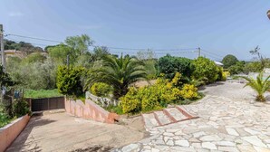A stone-paved outdoor area with a pool table and chairs, surrounded by lush greenery and palm trees. - Club Villamar - Nice and cozy villa with private pool, located in a quiet area with nice views (Macanet de la selva)