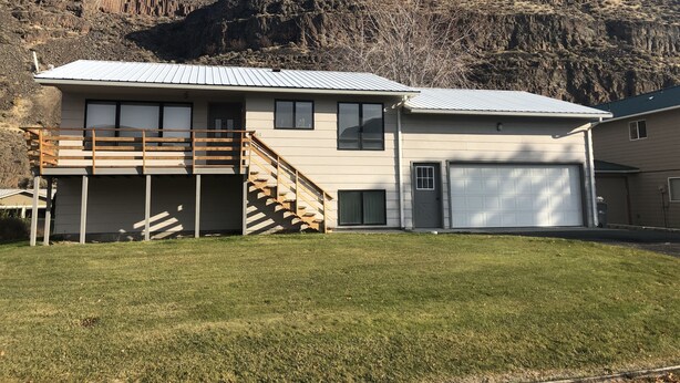 A two-story house with a balcony, a staircase, and a garage.