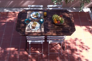 Enjoy a meal al fresco in this outdoor dining area, set with a table and comfortable chairs.