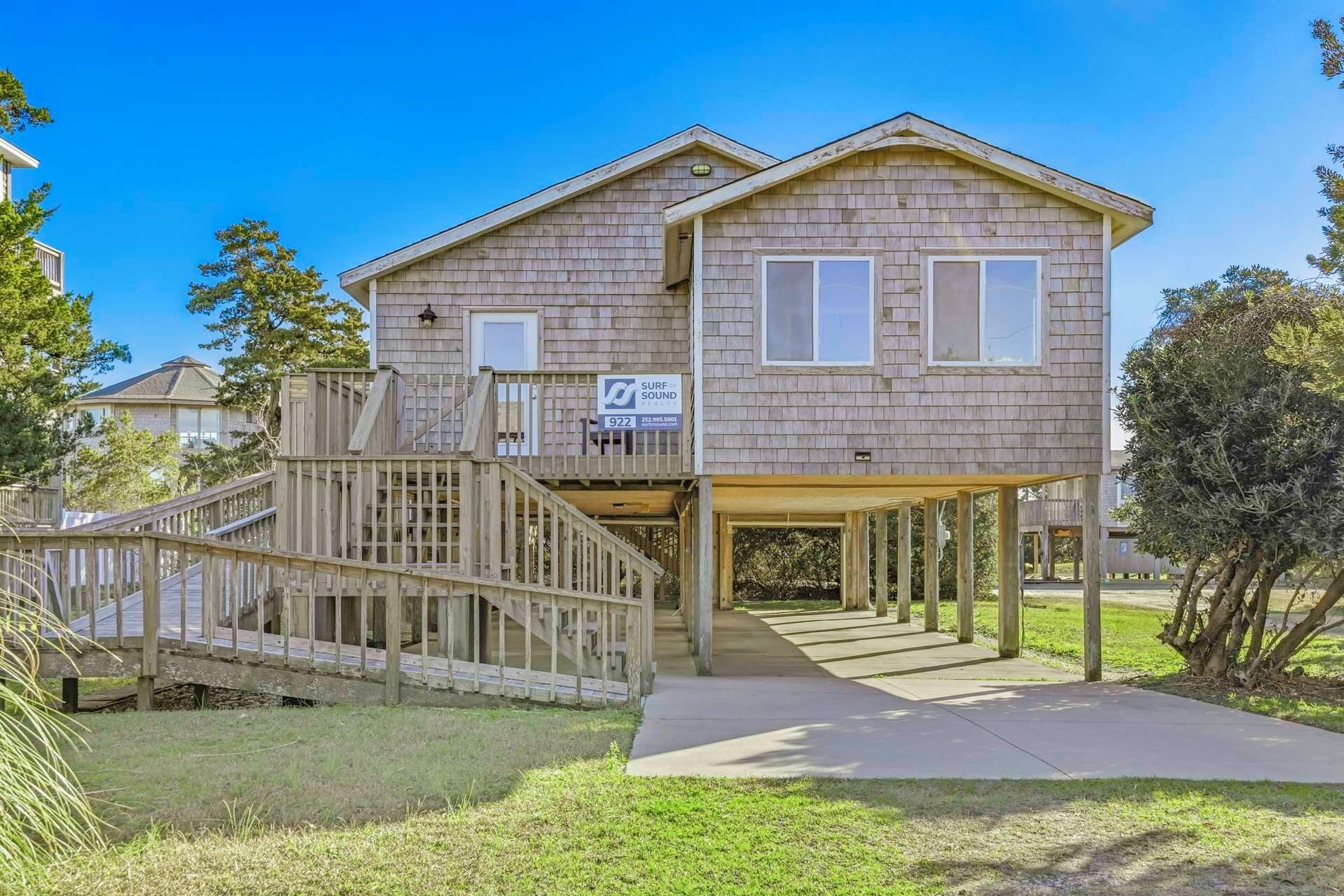 A two-story house with a wooden deck and a covered porch.