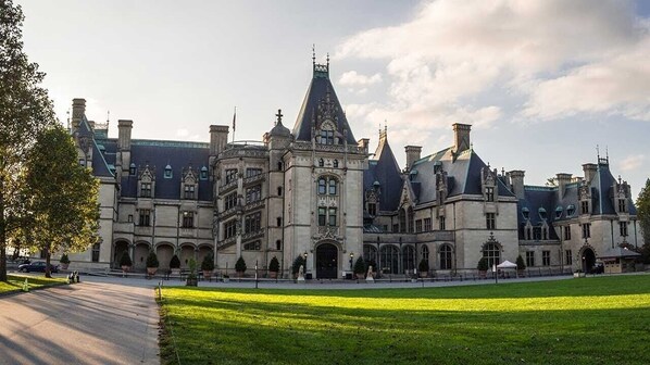 A large, historic building with a symmetrical facade, multiple chimneys, and a central tower. - Newer home in historic Hendersonville. Near Asheville and Blue Ridge Parkway! (Hendersonville)