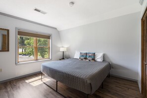 A bedroom with a large bed, a window with blinds, a nightstand, and a lamp. - Relaxing Suite Steps to Table Rock, Near Big Cedar, Community Hot Tub & Free Daily Tickets (Hollister)