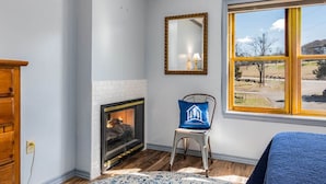 A room with a fireplace, a window with a view, a chair, and a mirror. - Relaxing Suite Steps to Table Rock, Near Big Cedar, Community Hot Tub & Free Daily Tickets (Hollister)