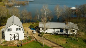 A large white house with a garage, a dock, and a boat. - Relaxing Suite Steps to Table Rock, Near Big Cedar, Community Hot Tub & Free Daily Tickets (Hollister)