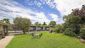 A well-maintained lawn with a dining area and a barbecue grill. - Hamilton Lakeside Motel (Hamilton)
