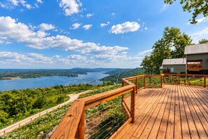 A wooden deck with a view of a lake and hills. - Cabin in the Sky with an outdoor kitchen! (Bryant)