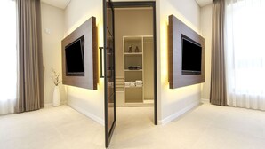 A modern hotel room with a built-in TV on the walls, a walk-in closet, and a large window with curtains. - Hermon Hotel Gangseo (Busan)