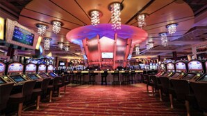 A casino with multiple slot machines, a central stage, and a red carpeted floor. - Pocono’s Mountain winter getaway! (Tobyhanna)