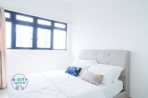 A bedroom with a bed, two pillows, a window, and a logo.