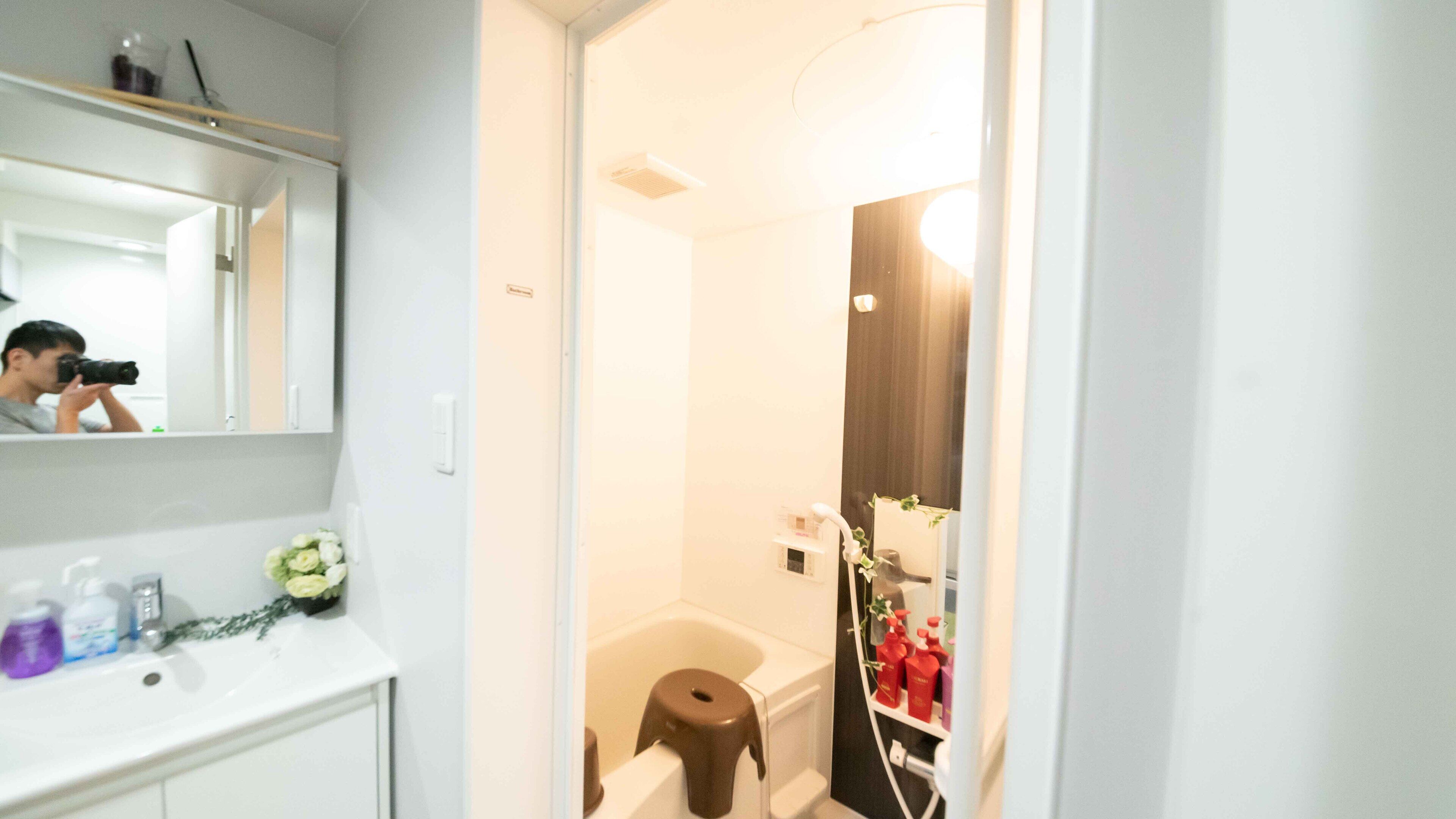 A bathroom with a white sink, mirror, and a shower area.