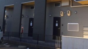 Un edificio dal design architettonico moderno, con un tetto piatto e una serie di finestre rettangolari.