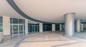 Un vaste espace intérieur doté d’un plafond incurvé, de grandes portes vitrées et d’une colonne centrale.