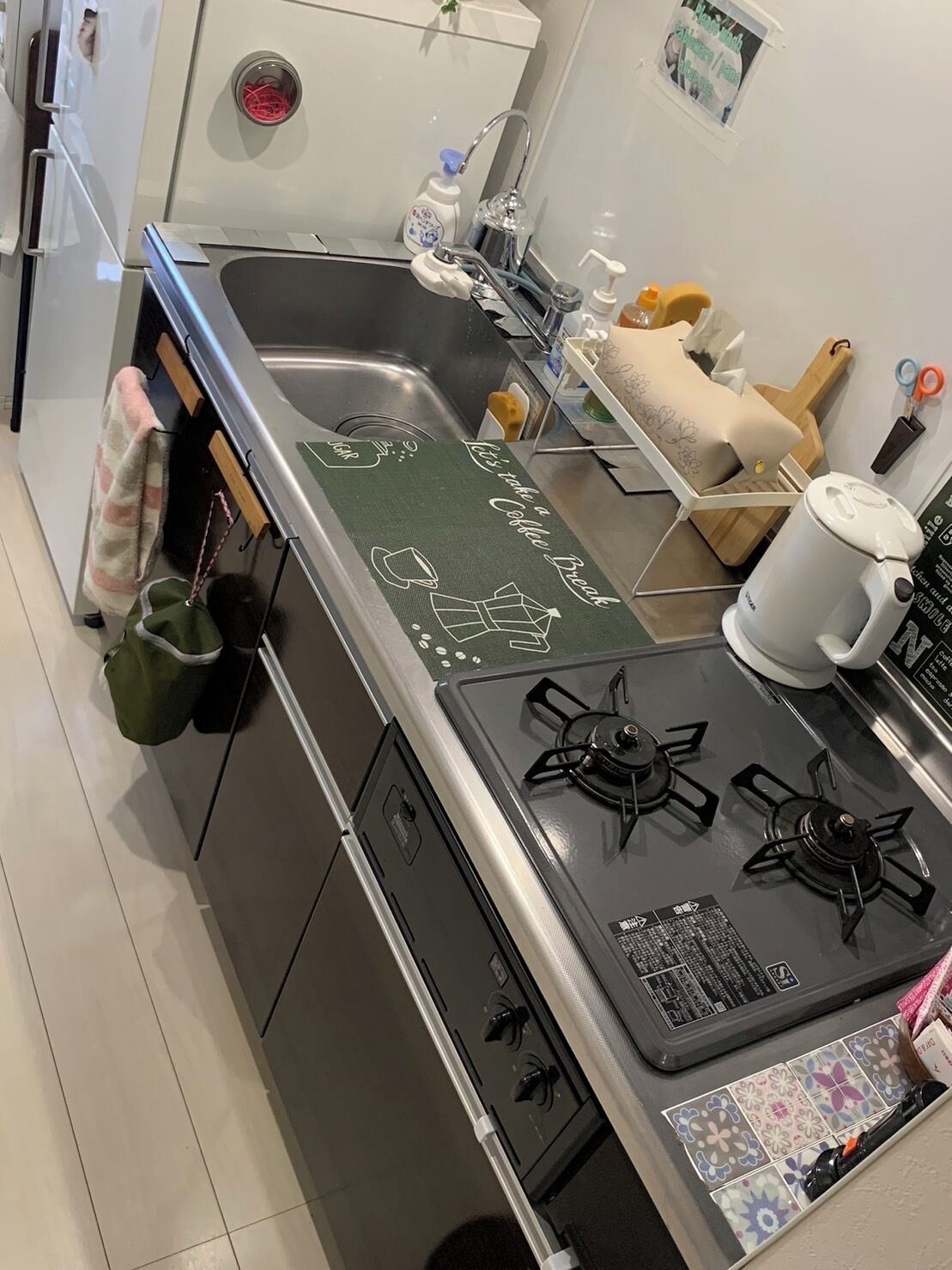 Eine Küche mit einem Gasherd, einer Kaffeemaschine und einem Spülbecken.
