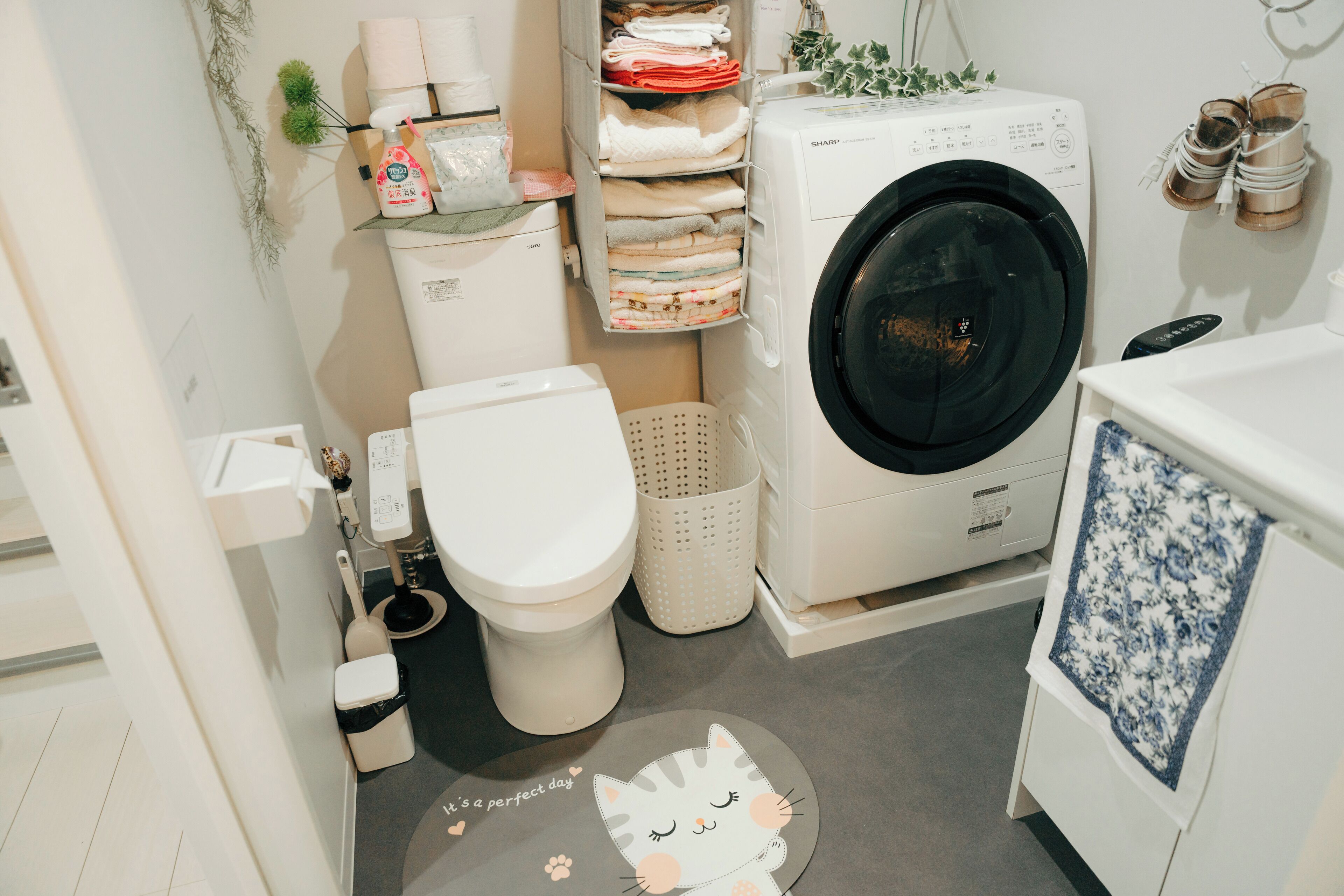 Een kleine badkamer met een wasmachine, toilet en een klein wastafelgedeelte.