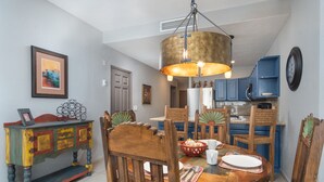 Un comedor con una mesa de madera, sillas y un armario colorido.