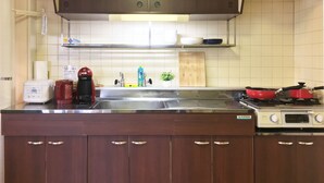 A kitchen with a stove, sink, and cabinets. - Sapporo-ENJU Nakanoshima 204 (Sapporo)