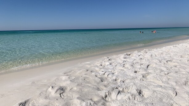 Una playa con aguas turquesas cristalinas y arena blanca.