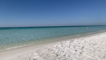 Uma praia com águas turquesa cristalinas e areia branca.