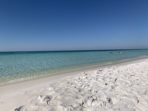 Uma praia com águas turquesa cristalinas e areia branca.
