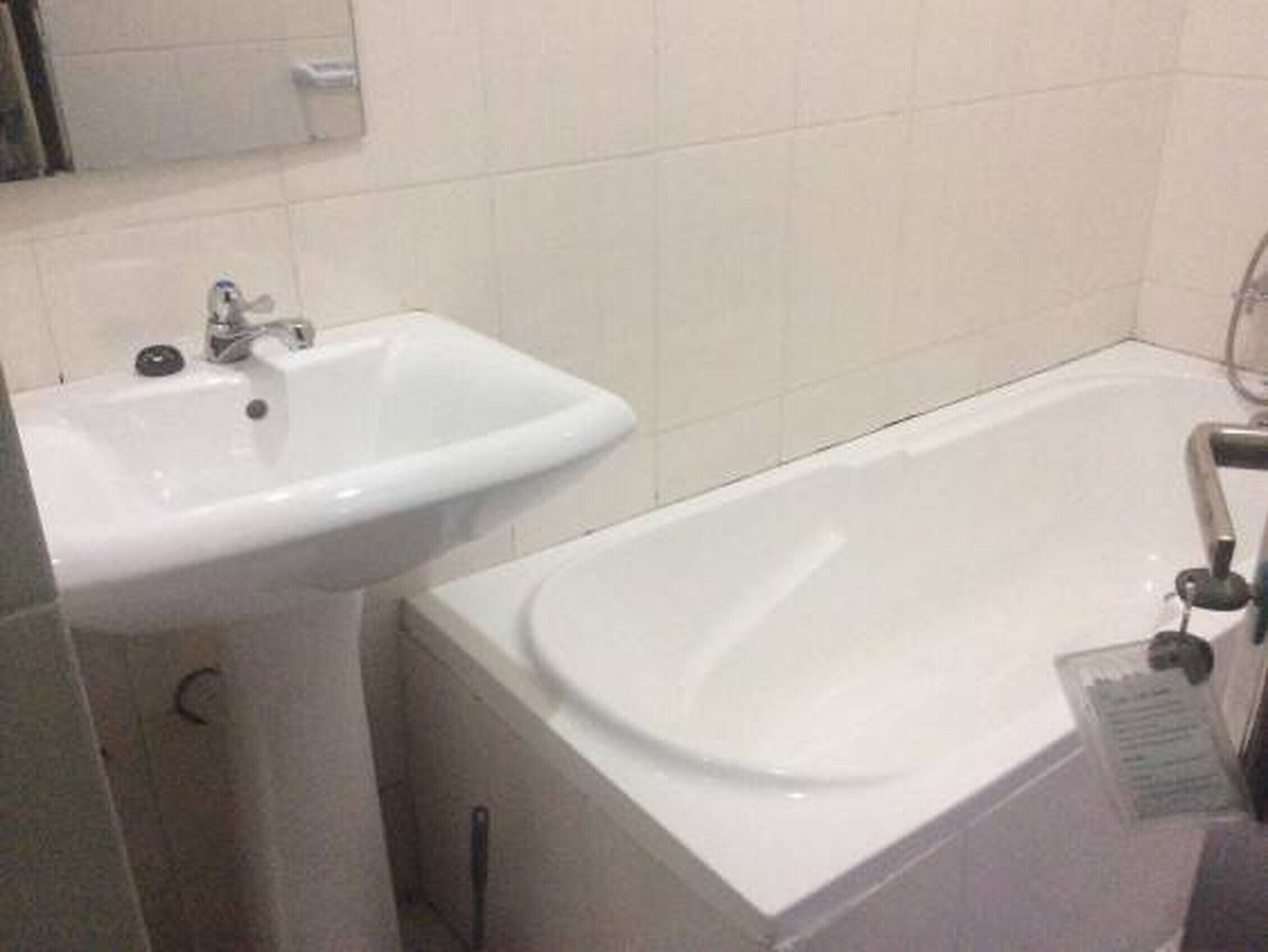 Un bagno con lavandino e vasca da bagno bianchi.