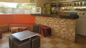 Interior de restaurant amb barra, zona de seients i terra enrajolada.