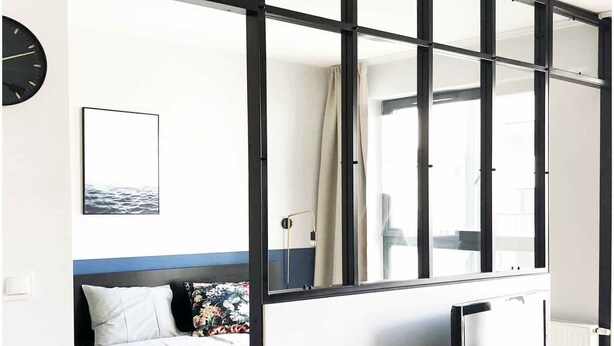 Une chambre moderne avec un lit, une télévision et des plantes en pot.
