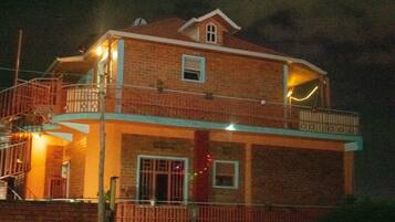 A two-story brick house with a balcony on the upper floor.
